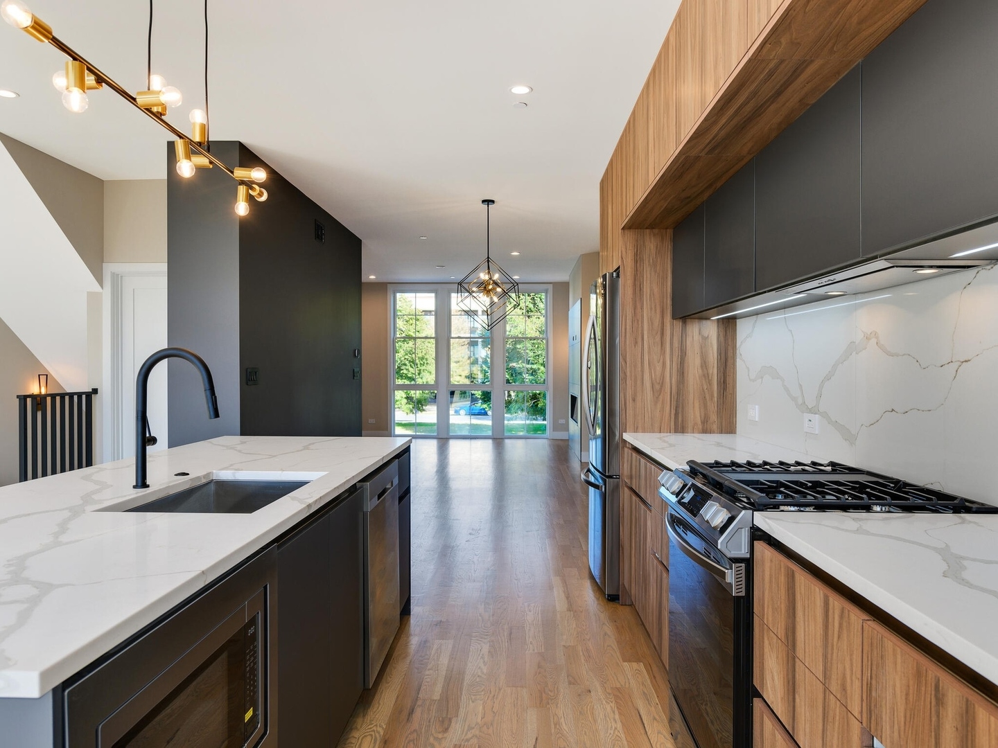 4448 South Drexel Boulevard, Unit A Chicago, IL 60653 - Photo 8 of 16 a kitchen with granite countertop a stove a sink dishwasher and a black countertop with wooden floor