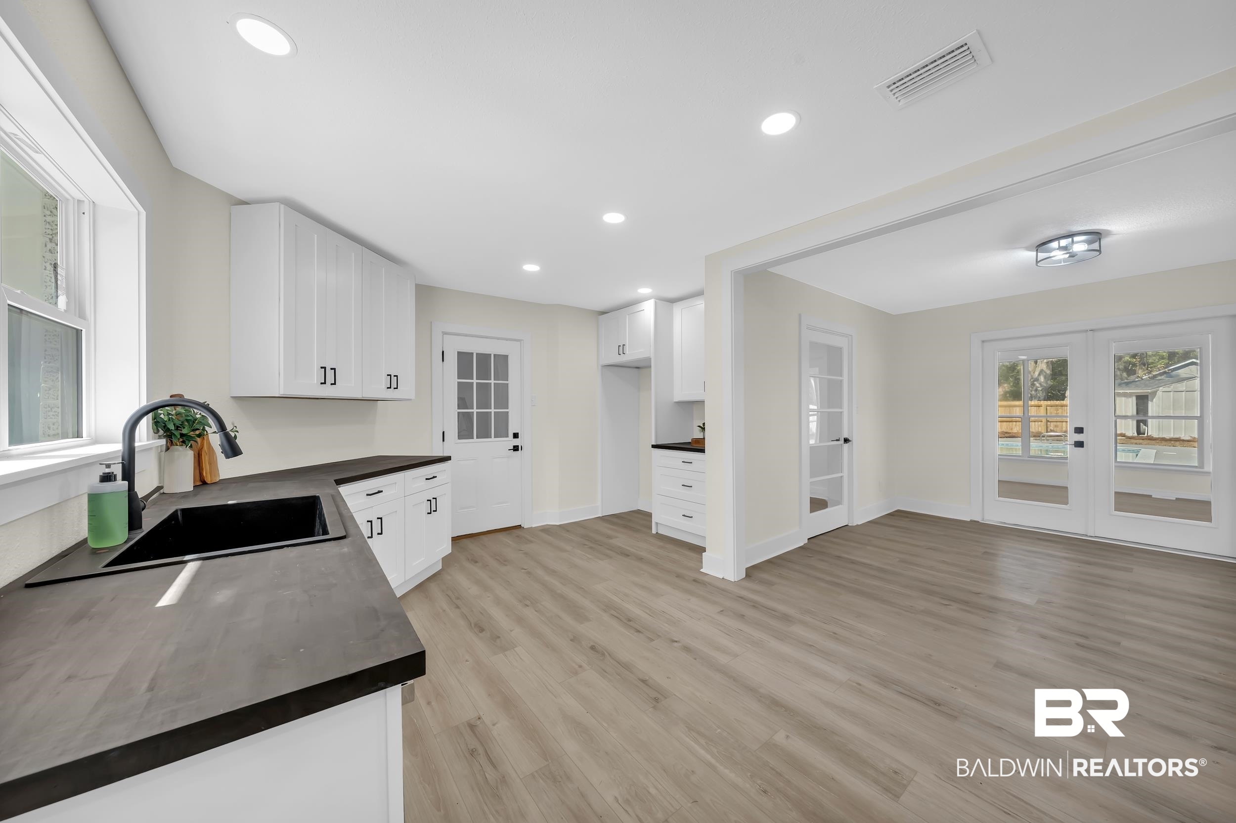 1409 Altair Lane Mobile, AL 36693 - Photo 9 of 23 Kitchen with dark countertops, white cabinets, french doors, light wood finished floors, and recessed lighting