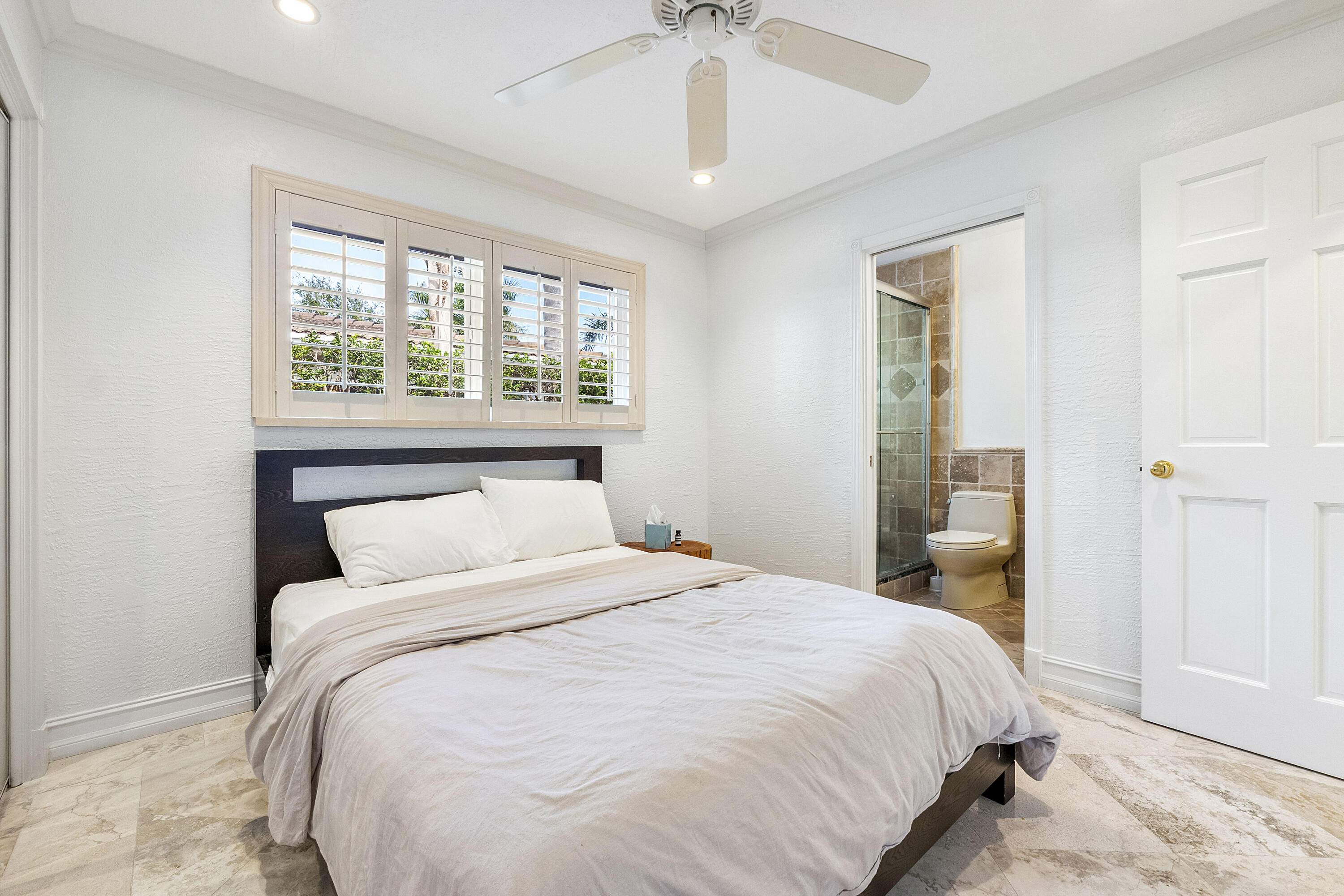 120 Southwest 8th Avenue Boca Raton, FL 33486 - Photo 24 of 38 a bedroom with a large bed and a chandelier