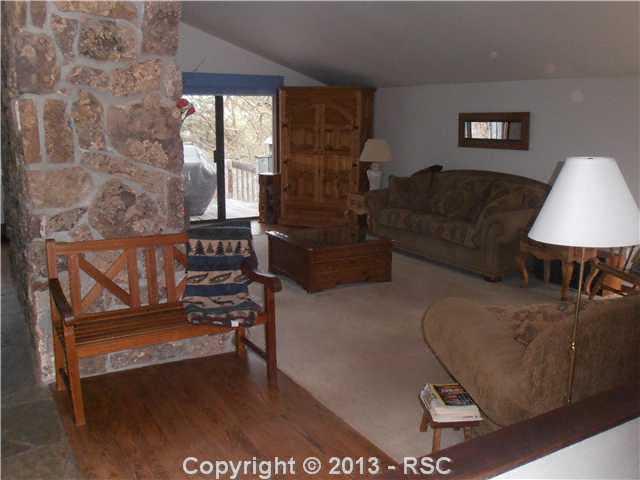 3685 El Rancho Way Monument, CO 80132 - Photo 14 of 25 note fireplace, wood floors and schist flooring