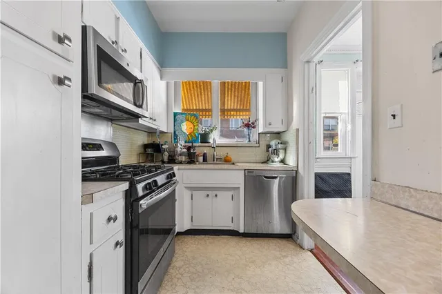 a kitchen with stainless steel appliances granite countertop a stove a sink and a microwave