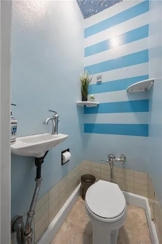 a bathroom with a sink a toilet and a mirror