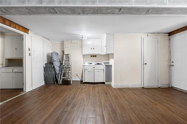 a view of a kitchen with refrigerator and wooden floor