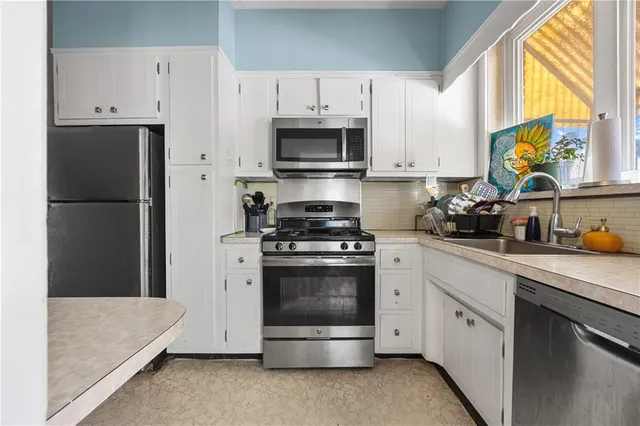 a kitchen with cabinets and stainless steel appliances