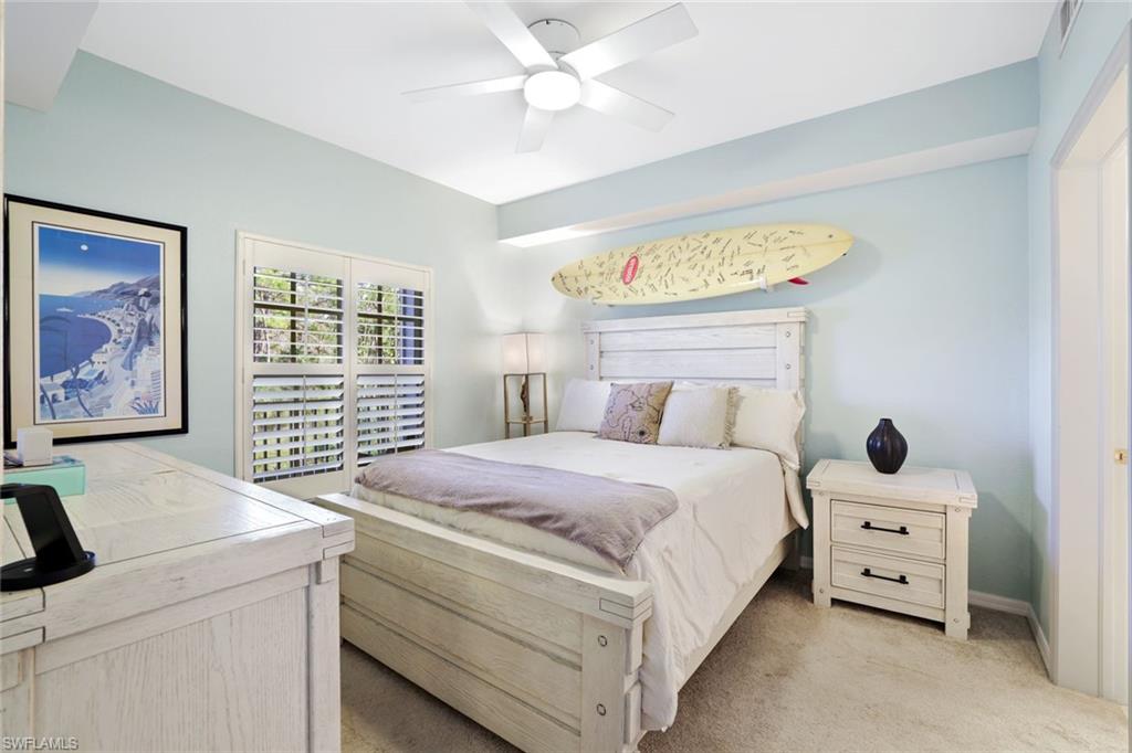 4455 Botanical Pl Circle, Unit 204 Naples, FL 34112 - Photo 12 of 26 a bedroom with a bed and a painting on the wall
