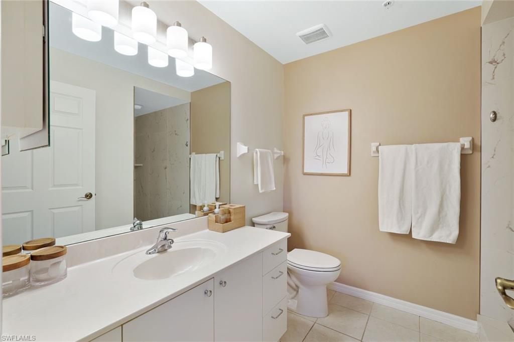 4455 Botanical Pl Circle, Unit 204 Naples, FL 34112 - Photo 14 of 26 a bathroom with a double vanity sink and a mirror