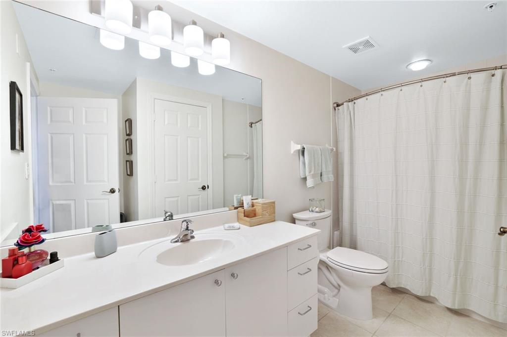 4455 Botanical Pl Circle, Unit 204 Naples, FL 34112 - Photo 17 of 26 a bathroom with a sink a toilet and a mirror