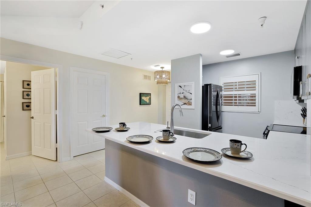4455 Botanical Pl Circle, Unit 204 Naples, FL 34112 - Photo 5 of 26 a bathroom with a sink and a mirror