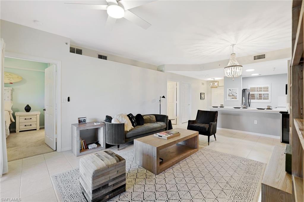 4455 Botanical Pl Circle, Unit 204 Naples, FL 34112 - Photo 9 of 26 a living room with furniture and a chandelier