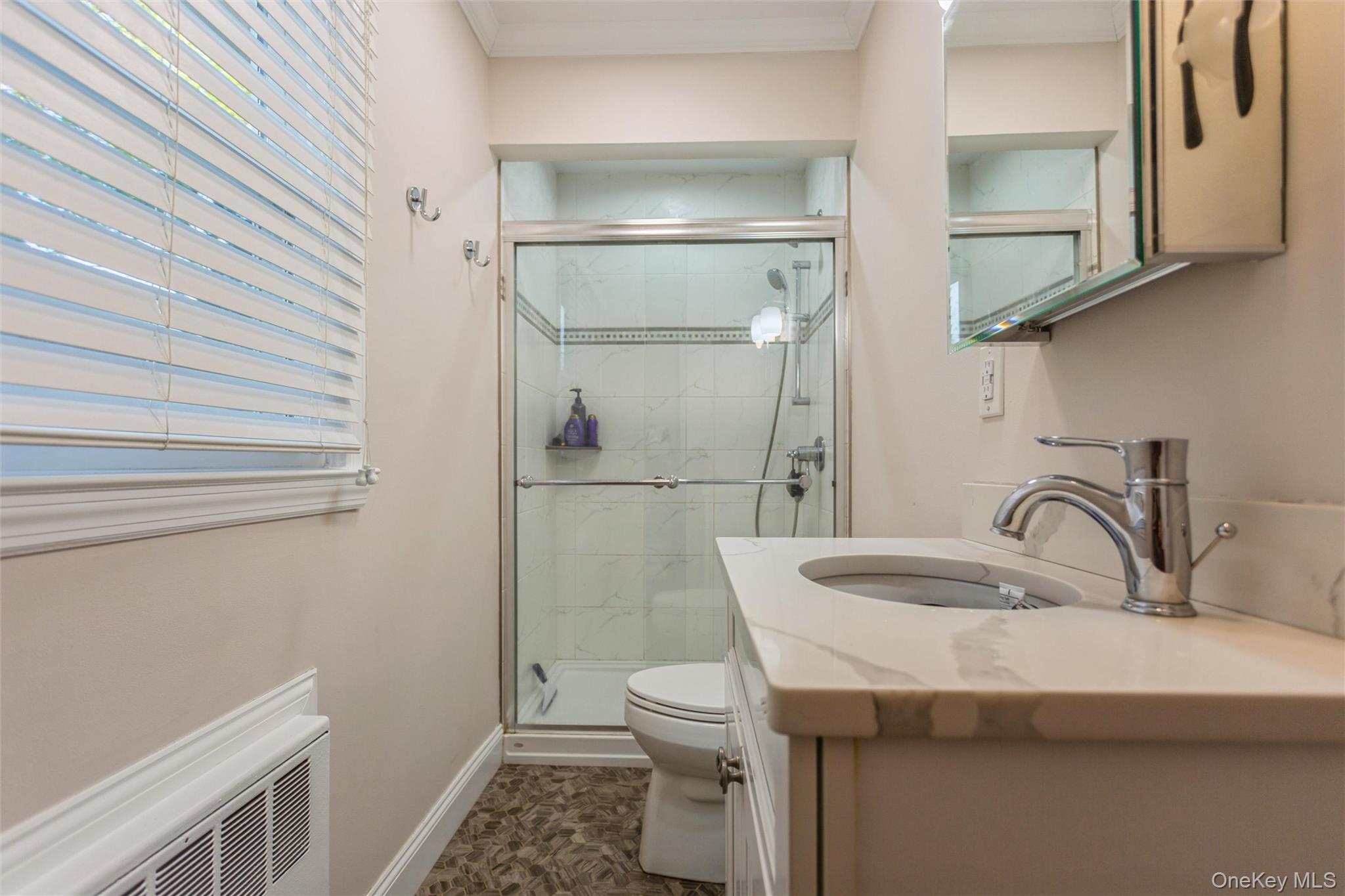 1531 Merrick Avenue Merrick, NY 11566 - Photo 14 of 26 Bathroom featuring vanity, a shower stall, ornamental molding, and radiator