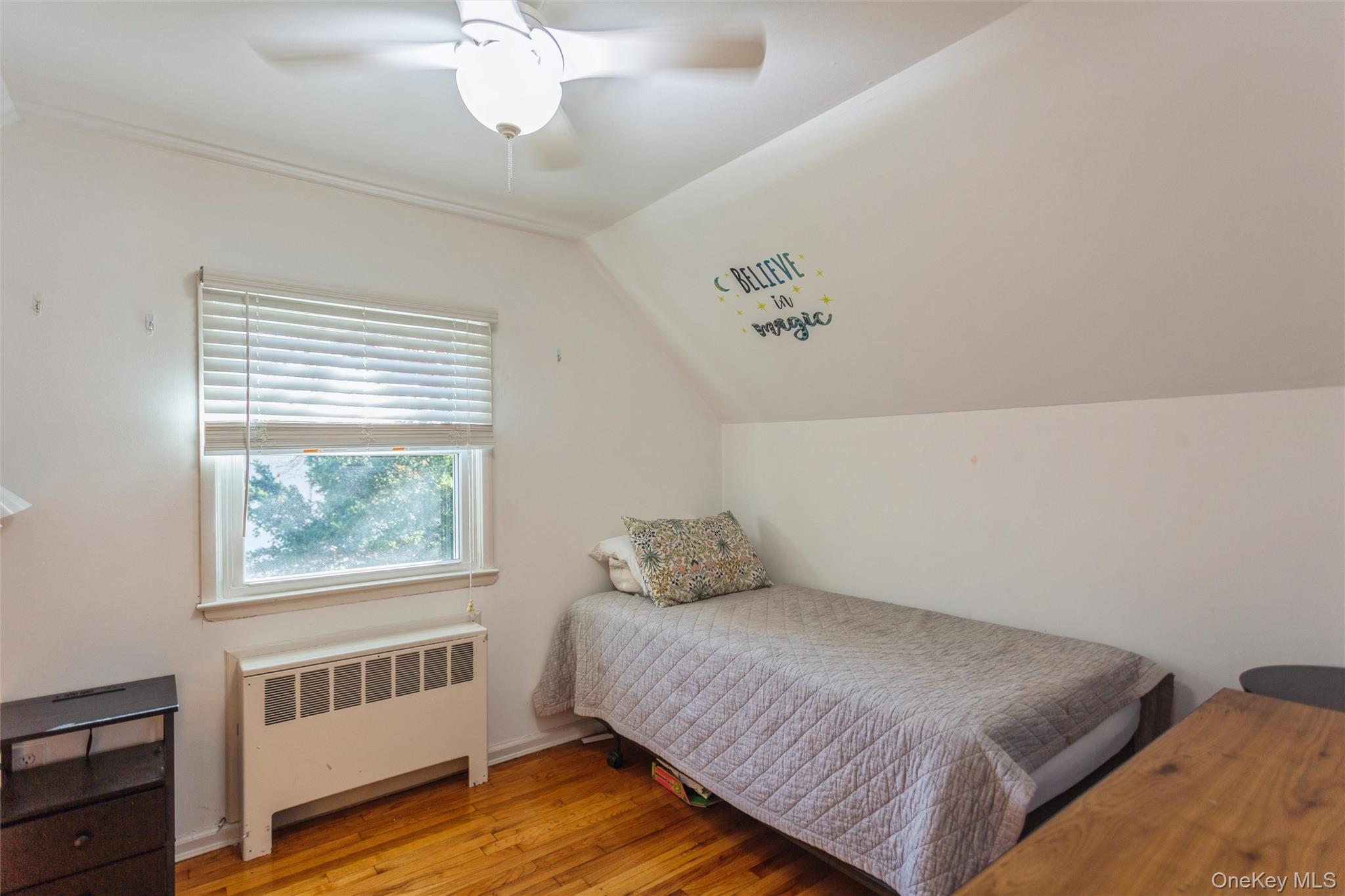 1531 Merrick Avenue Merrick, NY 11566 - Photo 18 of 26 Bedroom with radiator heating unit, light wood finished floors, vaulted ceiling, and ceiling fan