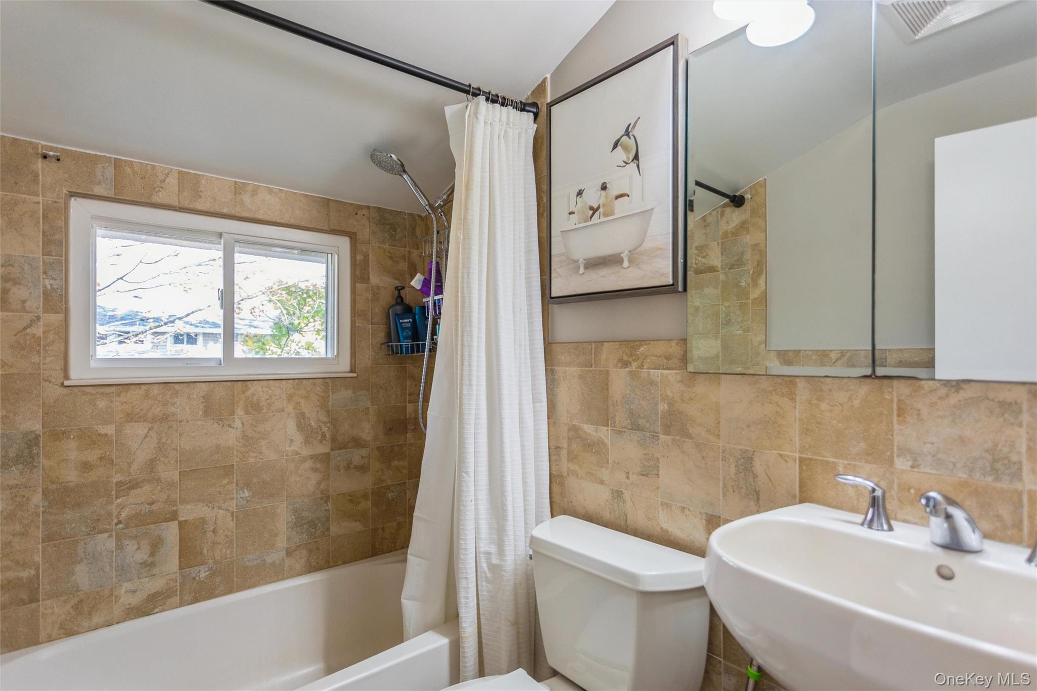 1531 Merrick Avenue Merrick, NY 11566 - Photo 19 of 26 Bathroom featuring shower / tub combo and tile walls