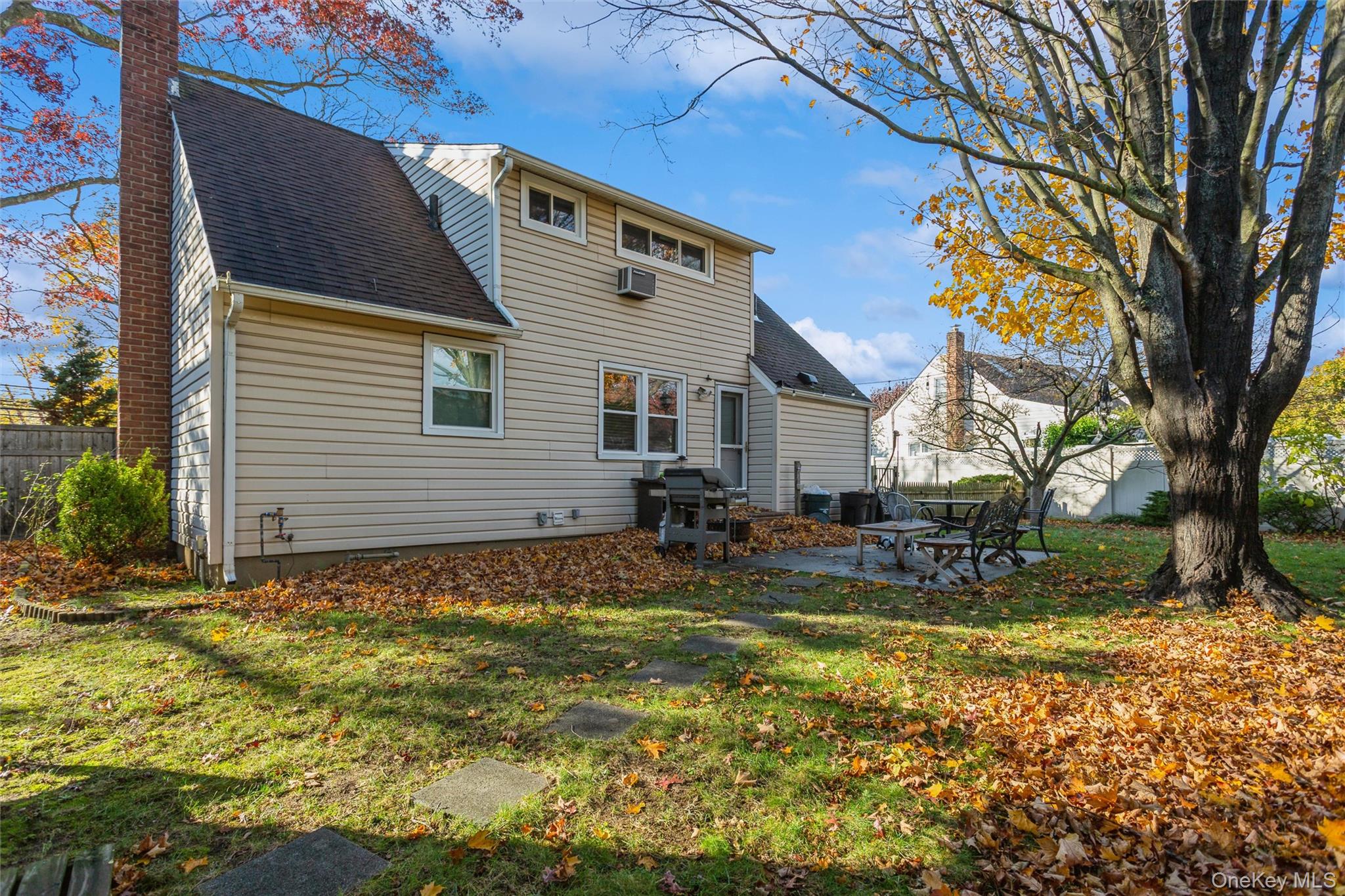 1531 Merrick Avenue Merrick, NY 11566 - Photo 24 of 26 Back of property featuring a patio area, roof with shingles, and a chimney