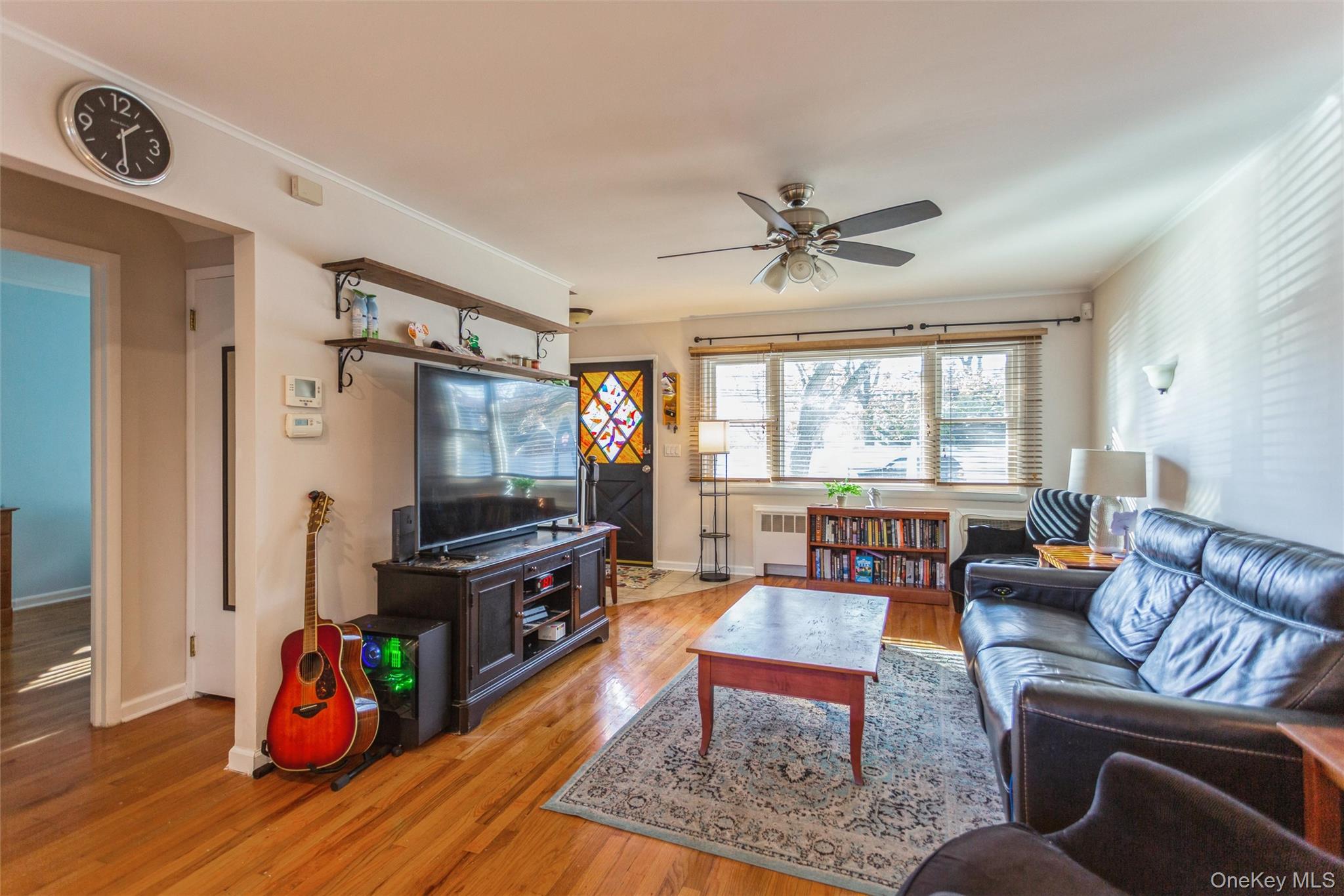 1531 Merrick Avenue Merrick, NY 11566 - Photo 7 of 26 Living area featuring wood finished floors, crown molding, radiator, and ceiling fan