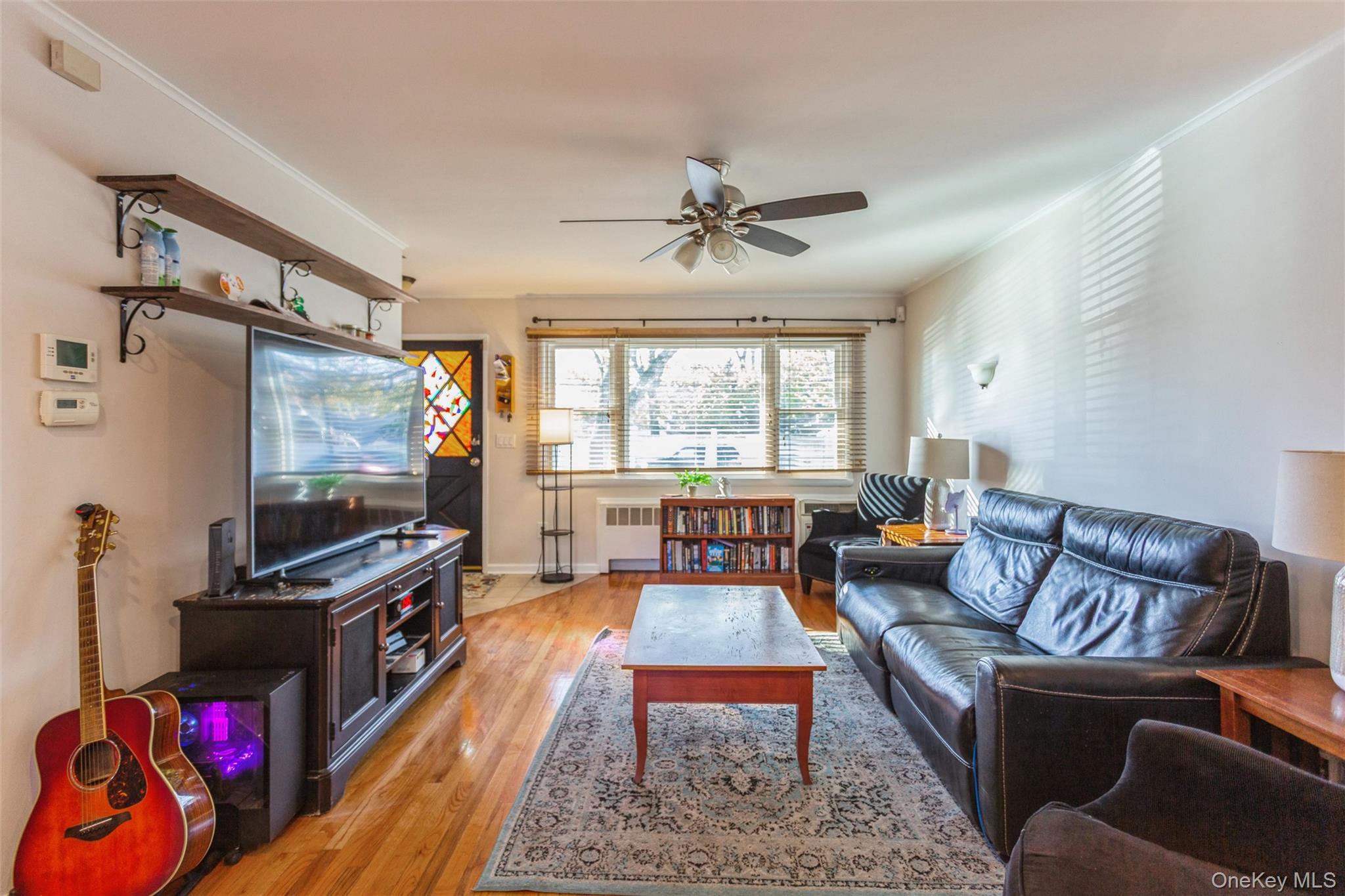 1531 Merrick Avenue Merrick, NY 11566 - Photo 8 of 26 Living room featuring ornamental molding, light wood-type flooring, radiator heating unit, and a ceiling fan
