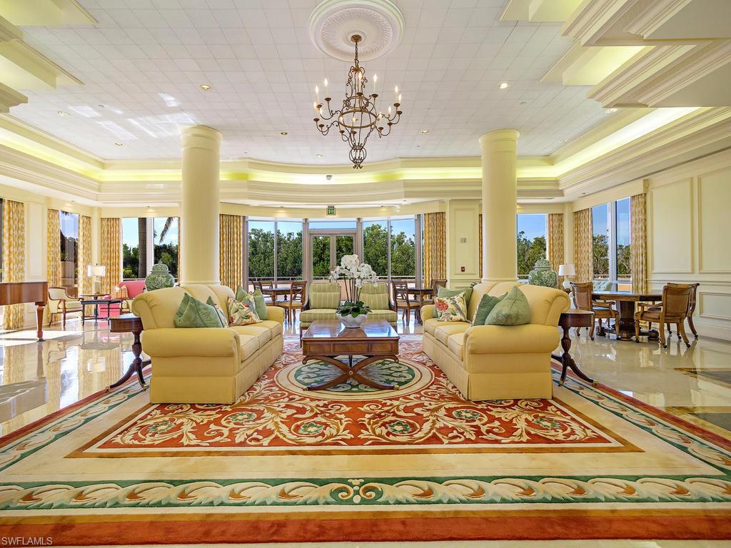6849 Grenadier Boulevard, Unit 2104 Naples, FL 34108 - Photo 11 of 13 a living room with furniture a chandelier and a rug