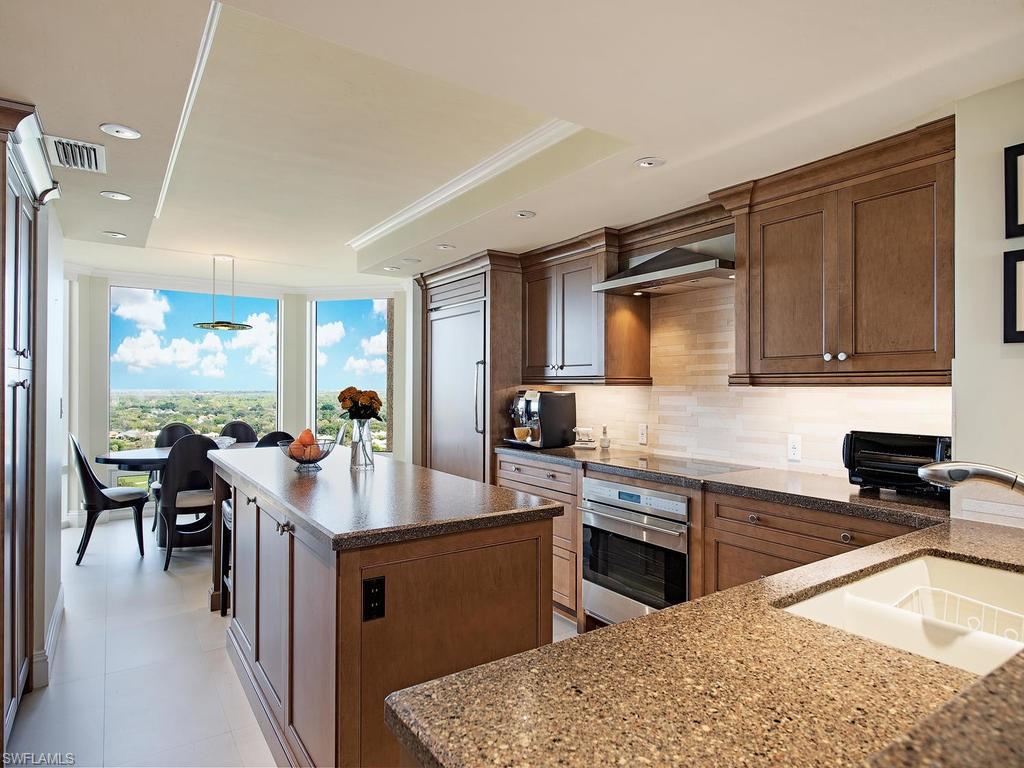 6849 Grenadier Boulevard, Unit 2104 Naples, FL 34108 - Photo 3 of 13 a kitchen with sink refrigerator and cabinets