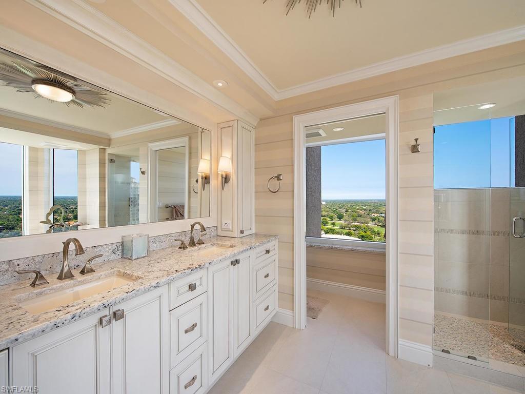 6849 Grenadier Boulevard, Unit 2104 Naples, FL 34108 - Photo 7 of 13 a bathroom with a granite countertop sink and a mirror