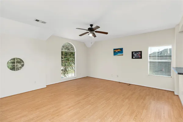 a view of a livingroom with a chandelier fan and a kitchen