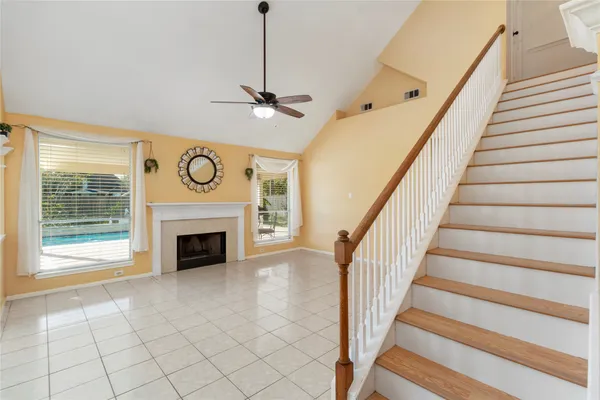 a view of an empty room wooden floor fireplace and a windows