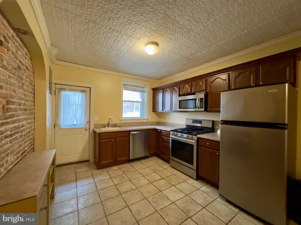 a kitchen with stainless steel appliances granite countertop a refrigerator and a stove