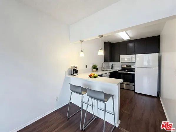 a kitchen with a table chairs refrigerator and microwave