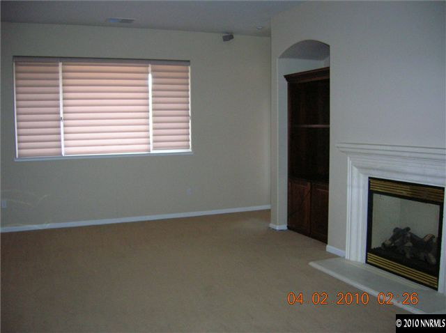 9900 Wilbur May, Unit 2601 Reno, NV 89521 - Photo 5 of 9 an empty room with a fireplace and a window