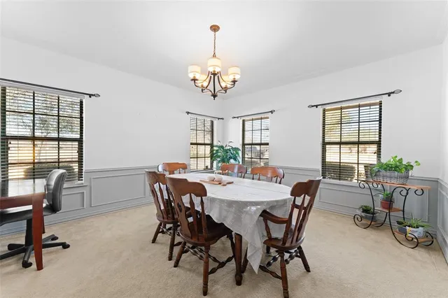 a view of a dining room with furniture a chandelier and wooden floor