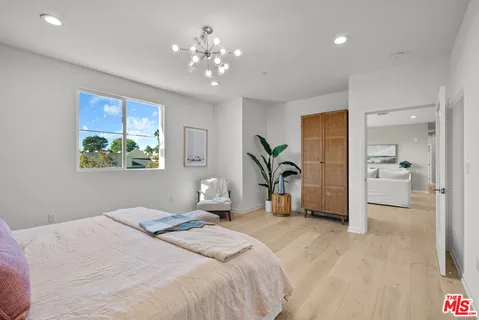a bedroom with a large bed and a chandelier