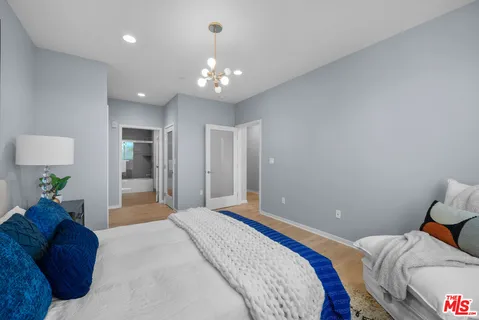 a spacious bedroom with a bed and a chandelier