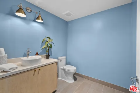 a bathroom with a sink mirror vanity and toilet