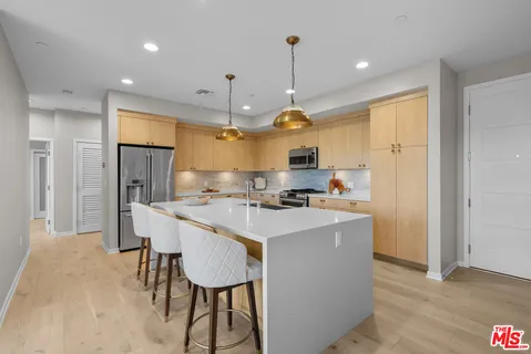a kitchen with a sink a stove a refrigerator and wooden floor