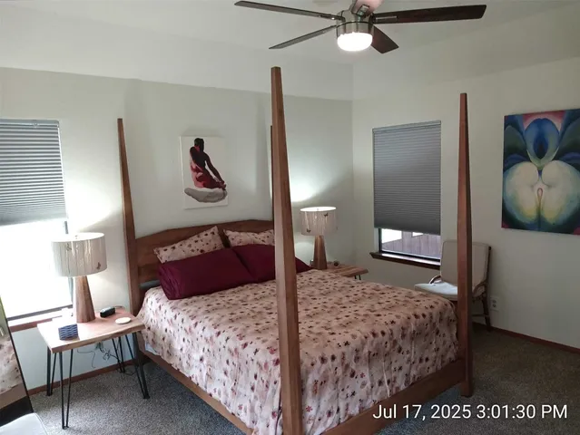 a bedroom with a bed and painting on the wall