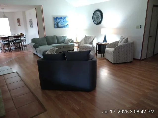 a living room with couches and a wooden floor