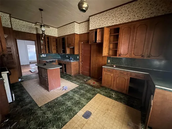 a kitchen with refrigerator and cabinets