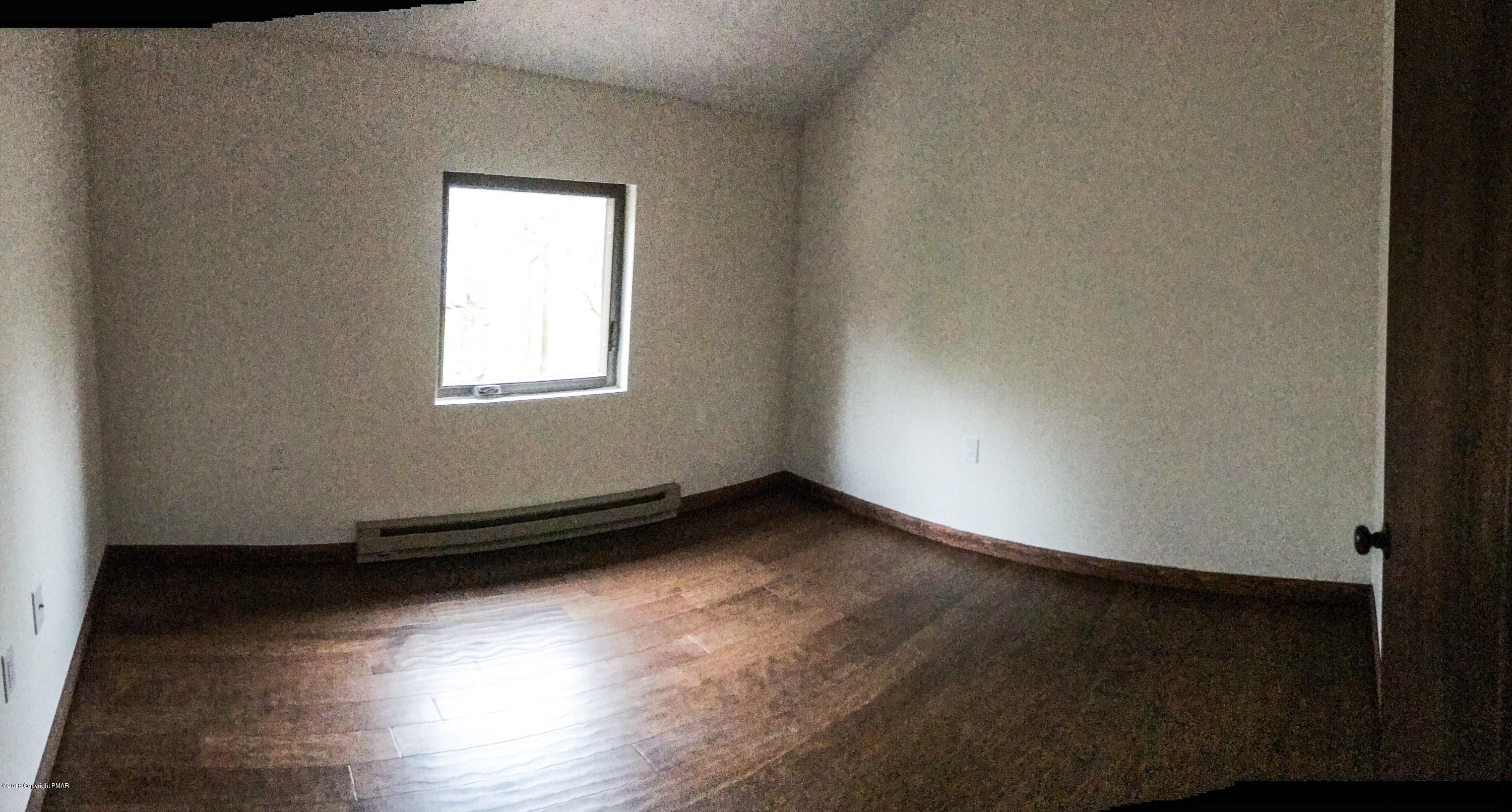 219 Ryan Road Blakeslee, PA 18610 - Photo 11 of 16 an empty room with wooden floor and windows