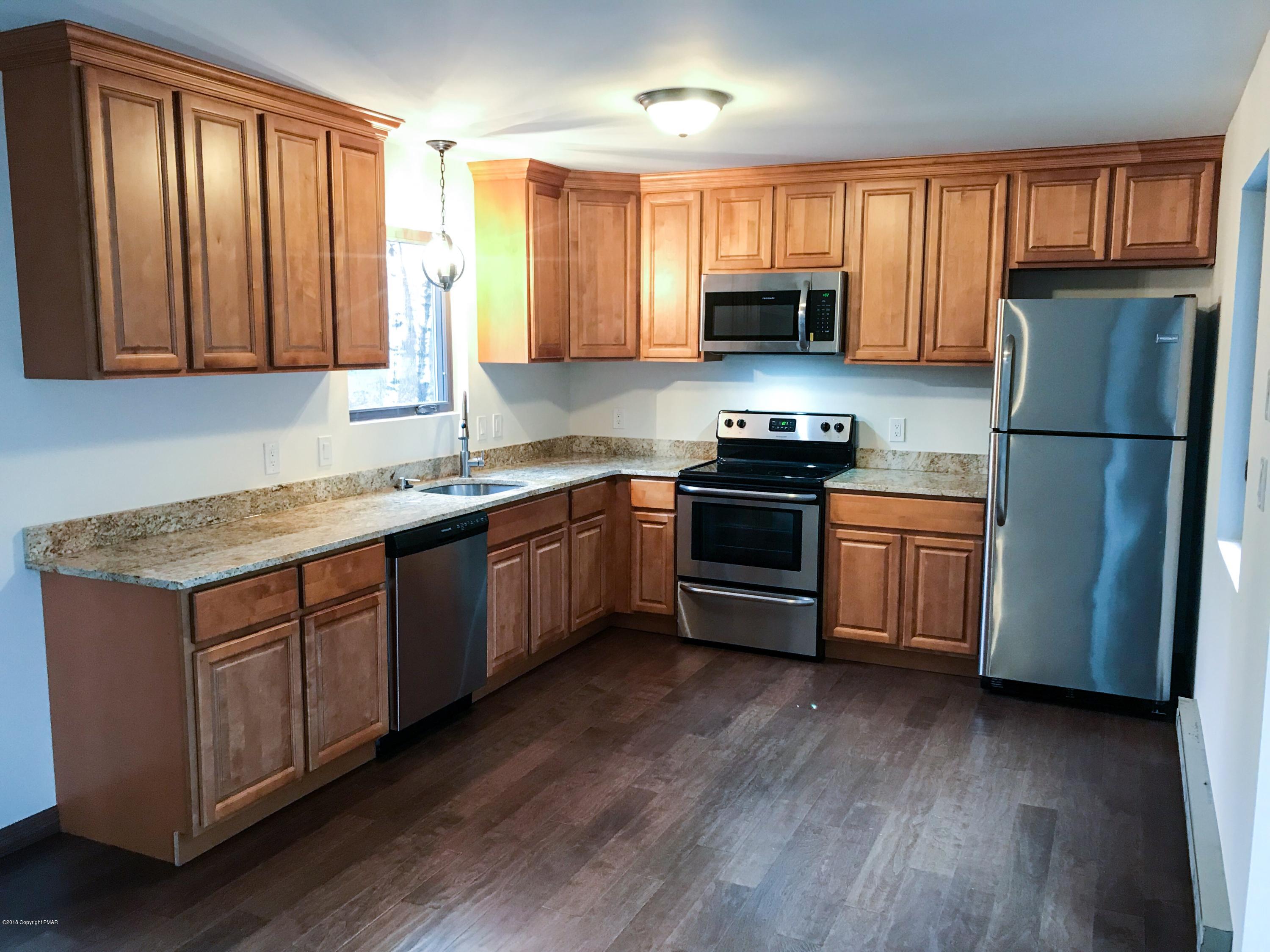 219 Ryan Road Blakeslee, PA 18610 - Photo 6 of 16 a kitchen with granite countertop wooden floors stainless steel appliances a sink and a window