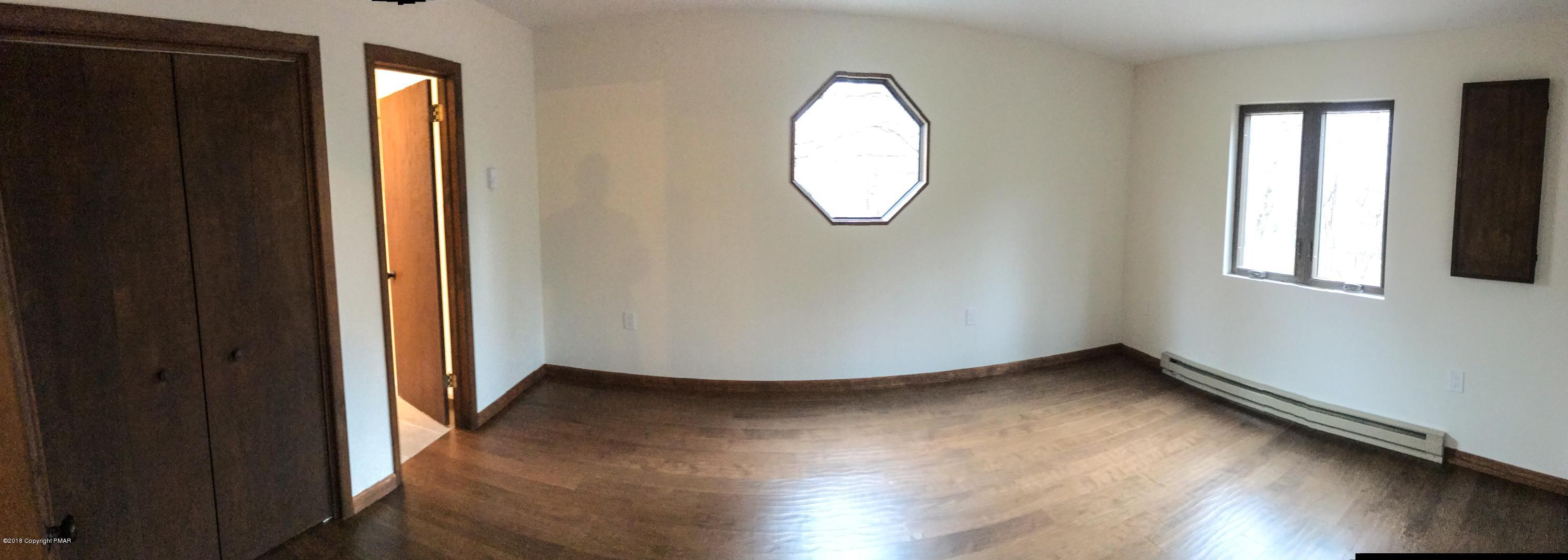 219 Ryan Road Blakeslee, PA 18610 - Photo 8 of 16 an empty room with wooden floor and windows