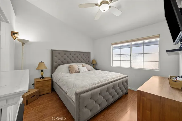 a bedroom with a bed a flat screen tv and a window