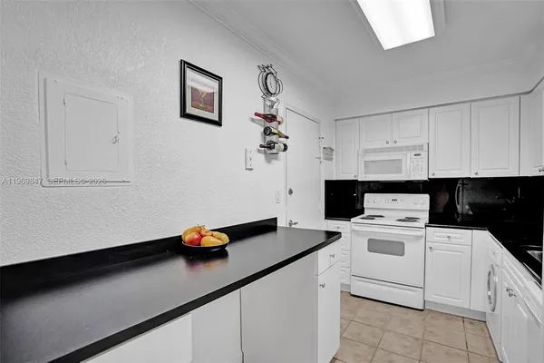 a kitchen with white cabinets and appliances