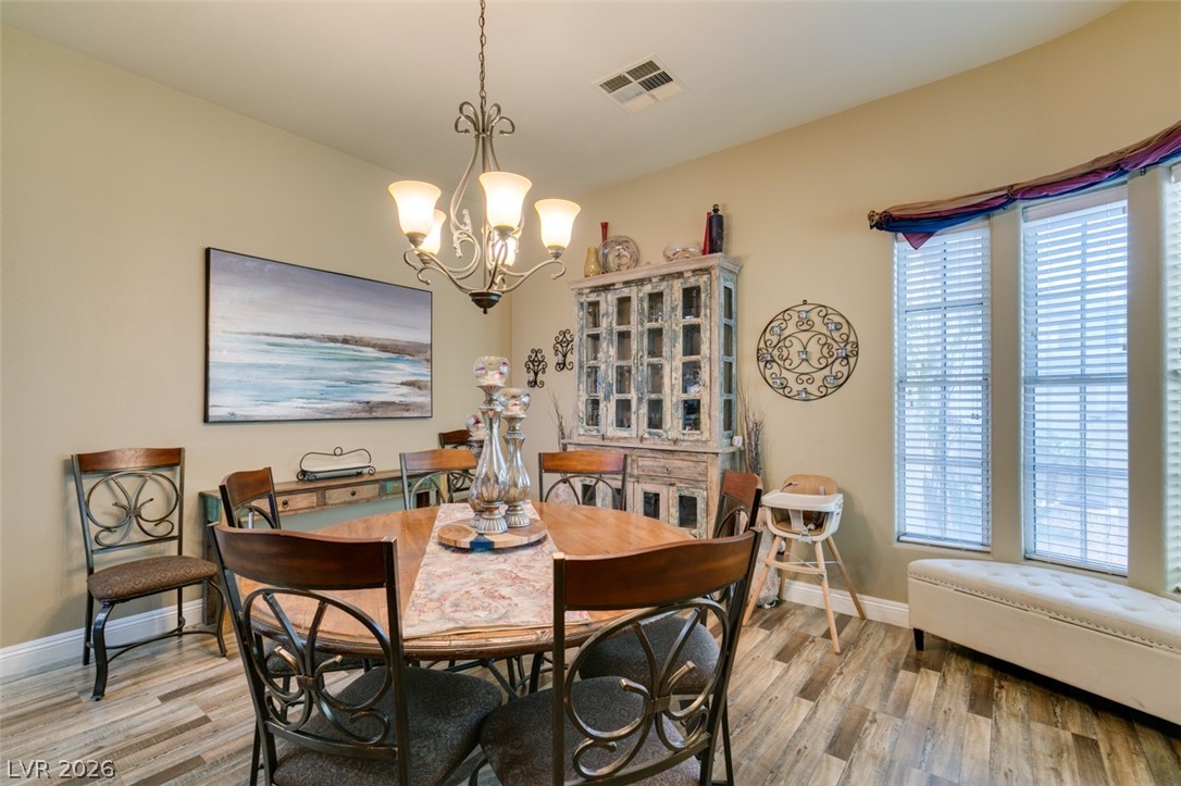 7524 Midnight Rambler Street Las Vegas, NV 89149 - Photo 25 of 51 Durable plank flooring and a classic chandelier illuminate this inviting dining space.