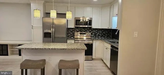 a kitchen with stainless steel appliances granite countertop a stove a refrigerator and a sink