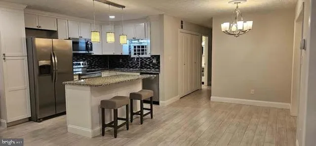 a kitchen with a refrigerator a sink and a wooden floor