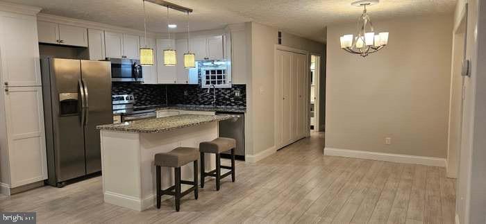 44693 White Oak Court, Unit 2B California, MD 20619 - Photo 4 of 14 a kitchen with a refrigerator a sink and a wooden floor