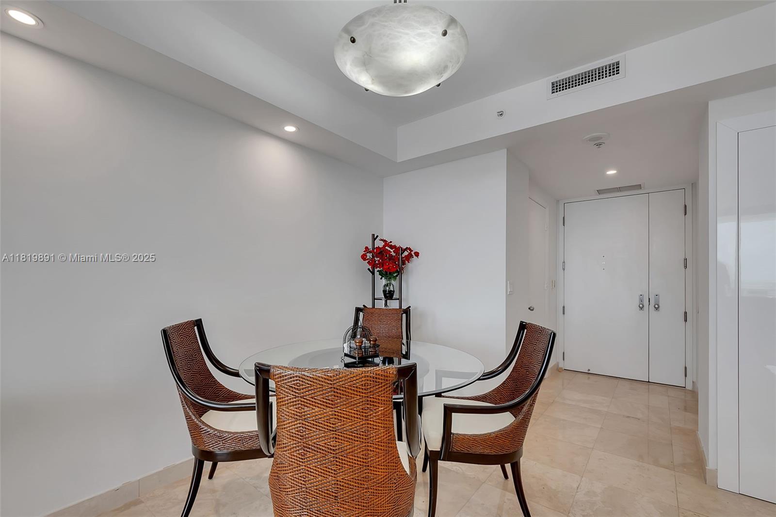 848 Brickell Key Drive, Unit 1803 Miami, FL 33131 - Photo 2 of 25 a dining room with furniture and wooden floor