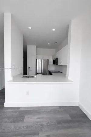 a view of kitchen with stainless steel appliances kitchen island sink and refrigerator