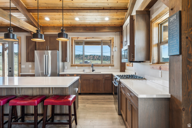 46997 West Thunder Road Fruitland, UT 84027 - Photo 13 of 49 Kitchen with stainless steel appliances, hanging light fixtures, a wood ceiling with exposed beams, a breakfast bar area, and recessed lighting