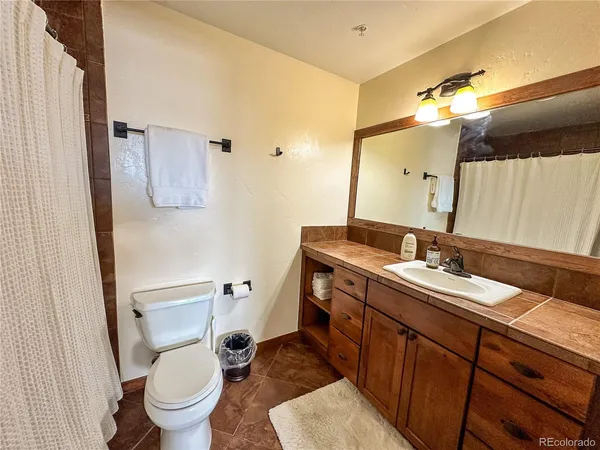 a bathroom with a double vanity sink mirror and toilet