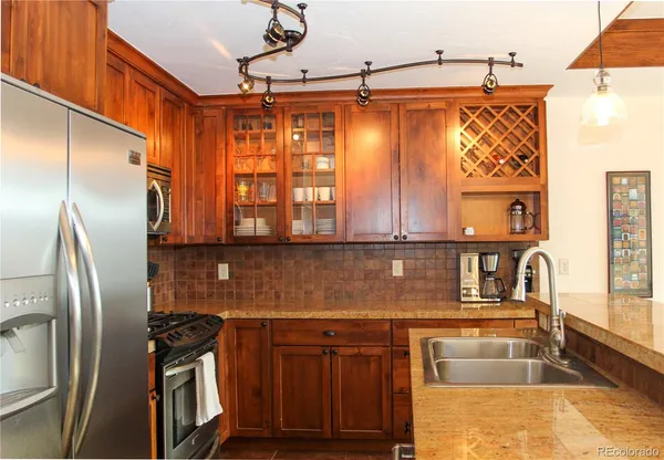 a kitchen with stainless steel appliances granite countertop a refrigerator and a sink