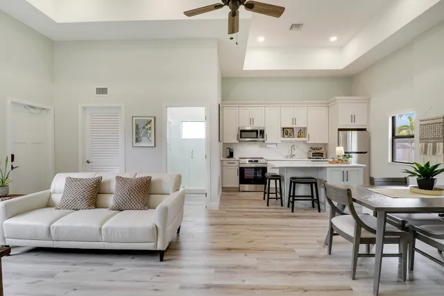 a living room kitchen with furniture and wooden floor